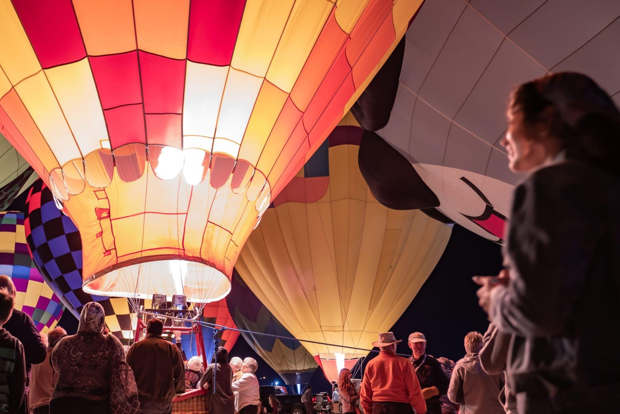 Illuminated hot air balloons glowing at dusk during an AEG-produced balloon festival